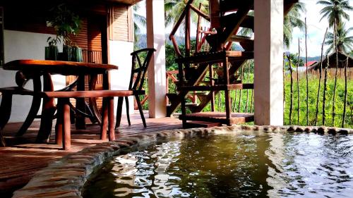 a pool of water with chairs and a table and stairs at Dreamer Resort in San Vicente