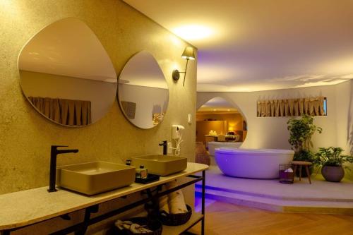 a bathroom with two sinks and a tub and mirrors at Aruanã Eco Praia Hotel in Aracaju