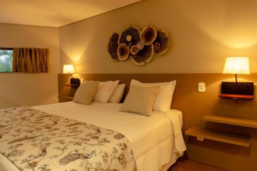 a bedroom with a bed and areath on the wall at Aruanã Eco Praia Hotel in Aracaju