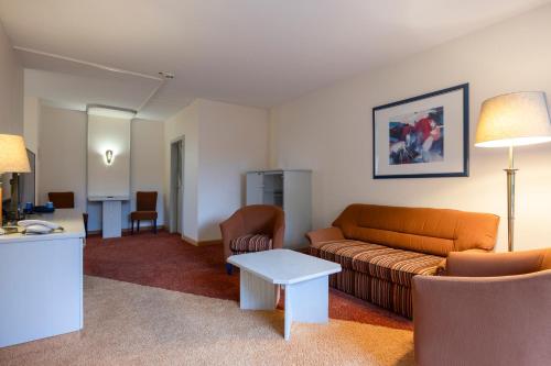 a living room with a couch and a table at Fletcher Hotel-Restaurant Arnsberg-Sauerland in Arnsberg