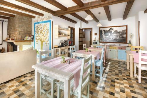 a kitchen with tables and chairs in a room at Hotel Rural El Mirador de los Pirineos in Santa Cruz de la Serós