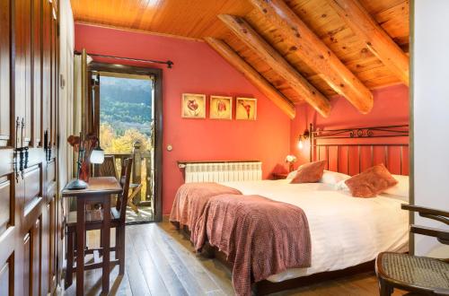 a bedroom with red walls and a large bed at Hotel Rural El Mirador de los Pirineos in Santa Cruz de la Serós
