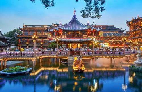 a building with a boat in the water in front at Dayin Youth Hostel - East Nanjing Road & People's Square & The Bund -Large Social Area -Bar -Café -Gym -Free Laundry Luggage Storage -24H Front Desk -English Service in Shanghai