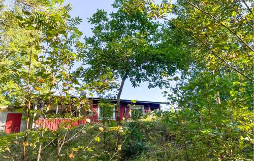 a house is seen through the trees at Cozy Home In Strömsnäsbruk With Wifi in Strömsnäsbruk