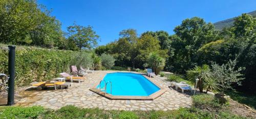 - une piscine dans une cour avec des chaises dans l'établissement Maison au cœur des Cévennes, à Molières-Cavaillac
