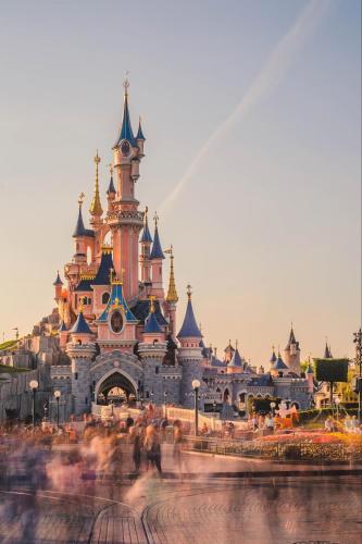 a disney castle with people walking in front of it at Dayin Youth Hostel - East Nanjing Road & People's Square & The Bund -Large Social Area -Bar -Café -Gym -Free Laundry Luggage Storage -24H Front Desk -English Service in Shanghai