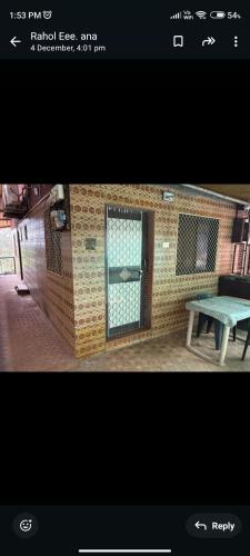 a door in a brick wall with a picnic table at Bluestar cottage in Matheran