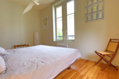 a bedroom with a bed and a window and a chair at Le Chalet Saint Vincent in Seurre