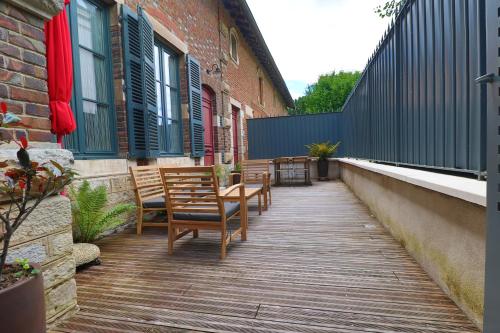a wooden walkway with chairs and tables on a building at Le Chalet Saint Vincent in Seurre