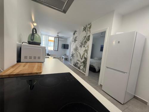 a kitchen with a white refrigerator and a room at Apartamento Playa Las Vistas in Arona