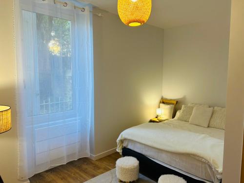 une chambre avec un lit et une grande fenêtre dans l'établissement T2 décoré avec soin centre-ville, à Lorient