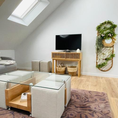 un salon avec un canapé et une télévision dans l'établissement Élégant T4 lumineux en centre-ville, à Lorient