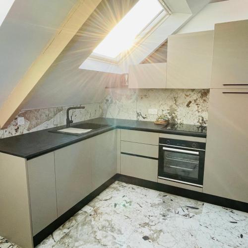 Il comprend une cuisine avec un évier et une lucarne. dans l'établissement Élégant T4 lumineux en centre-ville, à Lorient