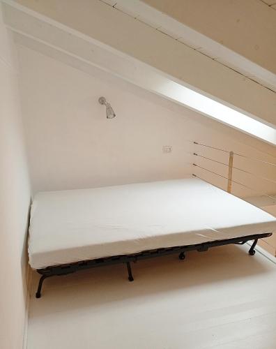 a bed in a room with a light at Roma 17 in Cassina deʼ Pecchi