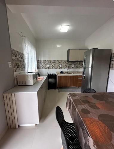 eine kleine Küche mit Kühlschrank und Spüle in der Unterkunft Casa para família em Bombinhas in Bombinhas