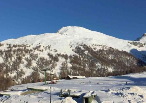 a snow covered mountain with a ski resort on it at Sestriere Gem Comfy Apartment with Ski Views in Sestriere