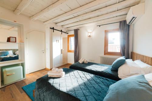a bedroom with two beds and a couch at Corte Lusenzo in Chioggia