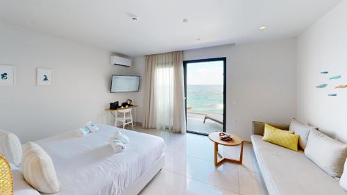 a white room with a bed and a couch at Maritime Suites in Hersonissos