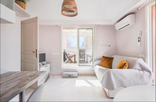 - un salon blanc avec un canapé et une fenêtre dans l'établissement 2P - terrasse - parking - plage, à Menton