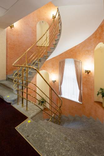 a spiral staircase in a building with a window at Wellness Hotel Jean De Carro in Karlovy Vary