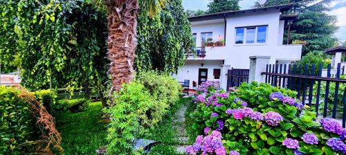a garden with purple flowers and a white house at Gemütliche Ferienwohnung in Agra in Agra
