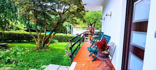 a porch with benches and a yard with trees at Gemütliche Ferienwohnung in Agra in Agra