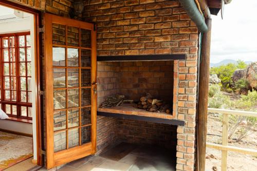 a brick fireplace in a room with a window at Wolfkop Nature Reserve in Citrusdal