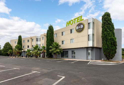an image of a hotel with a parking lot at B&B HOTEL Montpellier Vendargues in Saint-Aunès