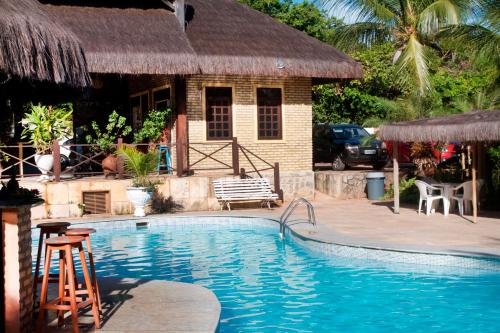 um resort com uma piscina e uma casa em Pousada Império do Sol em Pipa