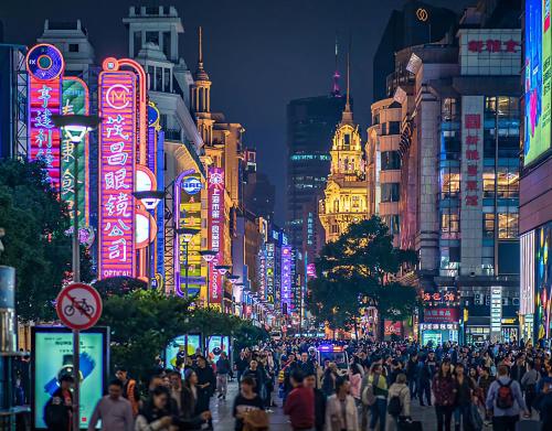 a crowd of people walking down a busy city street at night at Dayin Youth Hostel - Old Town & People's Square& Rail Hub -Social Area -Bar -Café -Gym -Free Laundry Luggage Storage -24H Front Desk -English Service in Shanghai