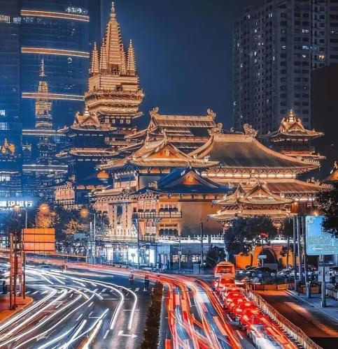a busy city street at night with a large building at Dayin Youth Hostel - Old Town & People's Square& Rail Hub -Social Area -Bar -Café -Gym -Free Laundry Luggage Storage -24H Front Desk -English Service in Shanghai