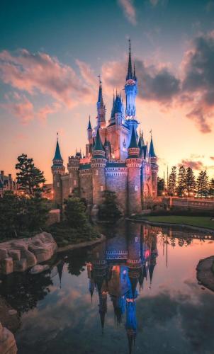 a castle with a reflection in the water at sunset at Dayin Youth Hostel - Old Town & People's Square& Rail Hub -Social Area -Bar -Café -Gym -Free Laundry Luggage Storage -24H Front Desk -English Service in Shanghai
