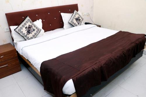 a bedroom with a large bed with a wooden headboard at hotel the silver in Chandīgarh