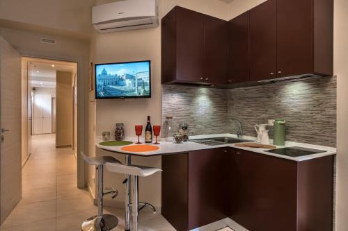 a kitchen with a sink and a bar with wine glasses at Guest House Grazioli in Rome