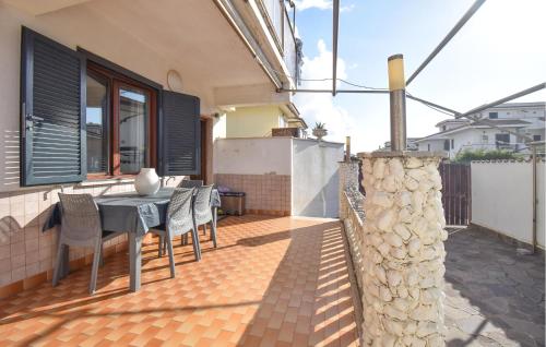 a patio with a table and chairs on a house at Gorgeous Apartment In Marina Di Ardea in LʼAmericano