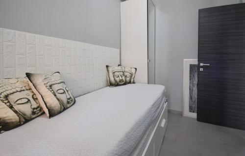 a white bed with pillows on it in a room at Gorgeous Apartment In Marina Di Ardea in LʼAmericano