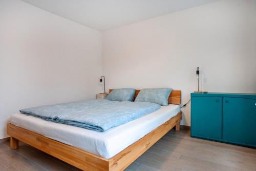 a bedroom with a bed and a blue cabinet at Tinas Ferienwohnung in Hergensweiler