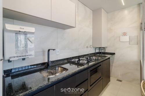 a kitchen with a sink and a stove at Lindo Estúdio Funcional em Goiânia SLV0011 in Goiânia