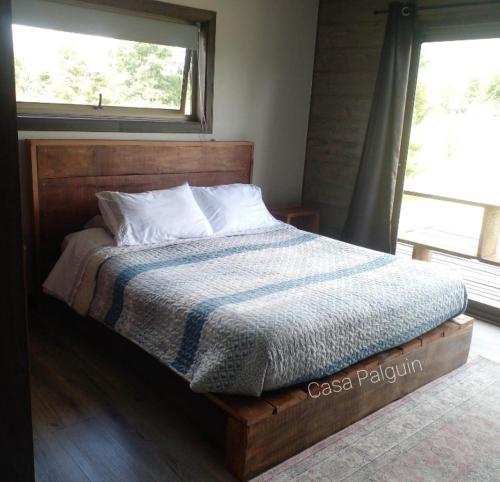 a bed with a blue and white blanket and a window at Hermosa casa en Palguin Bajo in Minetué