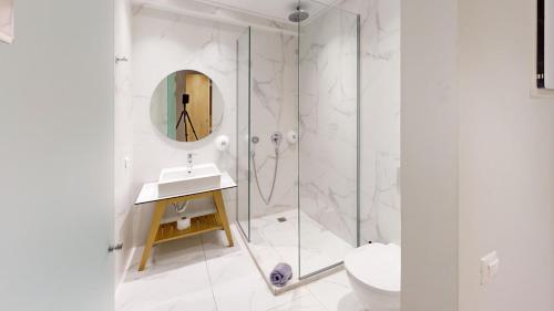 a bathroom with a shower and a sink and a mirror at Maritime Suites in Hersonissos