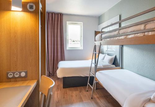 a small room with two bunk beds and a desk at B&B HOTEL Nantes Rezé St Sébastien in Saint-Sébastien-sur-Loire