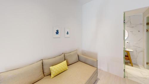 a couch with two yellow pillows in a living room at Maritime Suites in Hersonissos