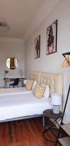 a bedroom with a large white bed and a table at Santa Maria Hostel in Funchal