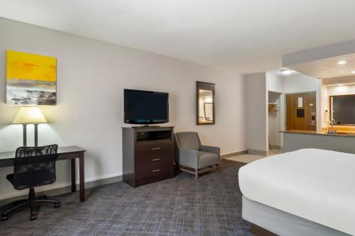a hotel room with a bed and a flat screen tv at Comfort Inn & Suites Mundelein-Vernon Hills in Mundelein