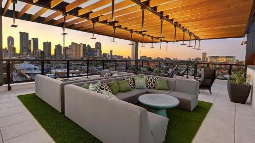 a rooftop patio with couches and a view of the city at Indie Deep Ellum in Dallas in Dallas