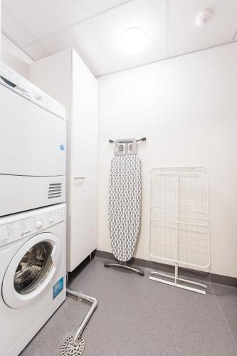 a laundry room with a washing machine and a washer at Forenom Aparthotel Espoo Leppävaara in Espoo
