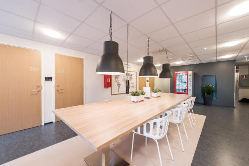 a large conference room with a wooden table and chairs at Forenom Aparthotel Espoo Leppävaara in Espoo