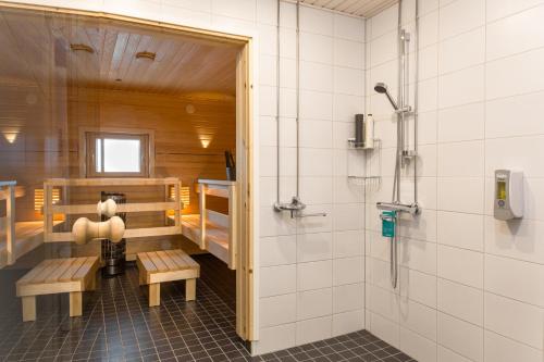 a bathroom with a shower and benches in a room at Forenom Aparthotel Espoo Leppävaara in Espoo