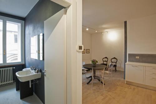 a bathroom with a sink and a table in a room at Palazzo Dalla Rosa Prati in Parma