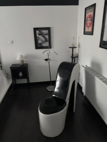a black and white room with a chair and a lamp at Le Blockhaus de Domléger et Spa in Domléger